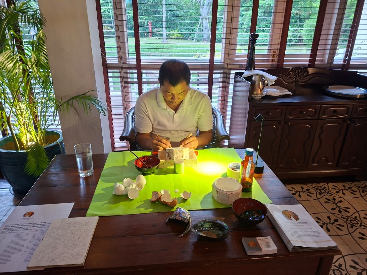 Master artisan pressing eggshell mosaic by hand at the Stocker Studio atelier in Siem Reap