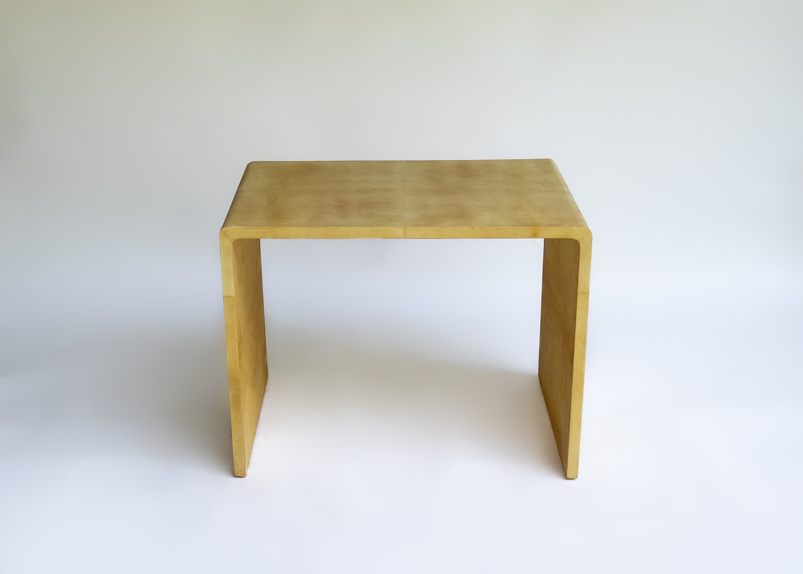 Stocker Studio compact waterfall side table finished in warm parchment-tone natural lacquer